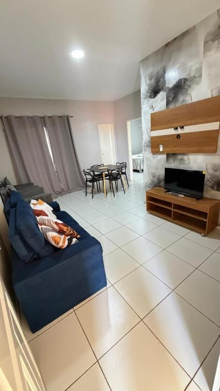 een woonkamer met een blauwe bank en een tafel bij Paulinos Flat 02, Ubajara CE in Ubajara