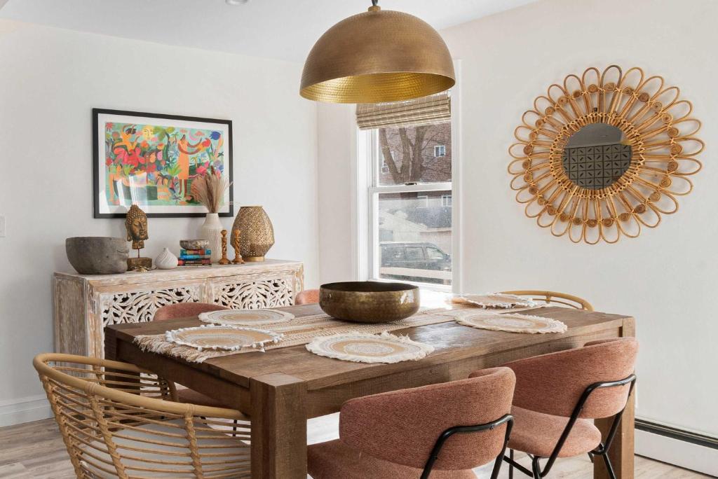 a dining room table with chairs and a gold mirror at The Return to Self - Walk to Historic Downtown in Warren