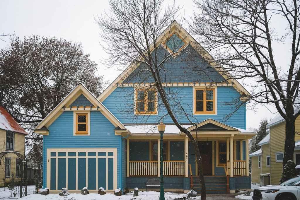 een blauw huis in de sneeuw op een straat bij Samson House in Revelstoke