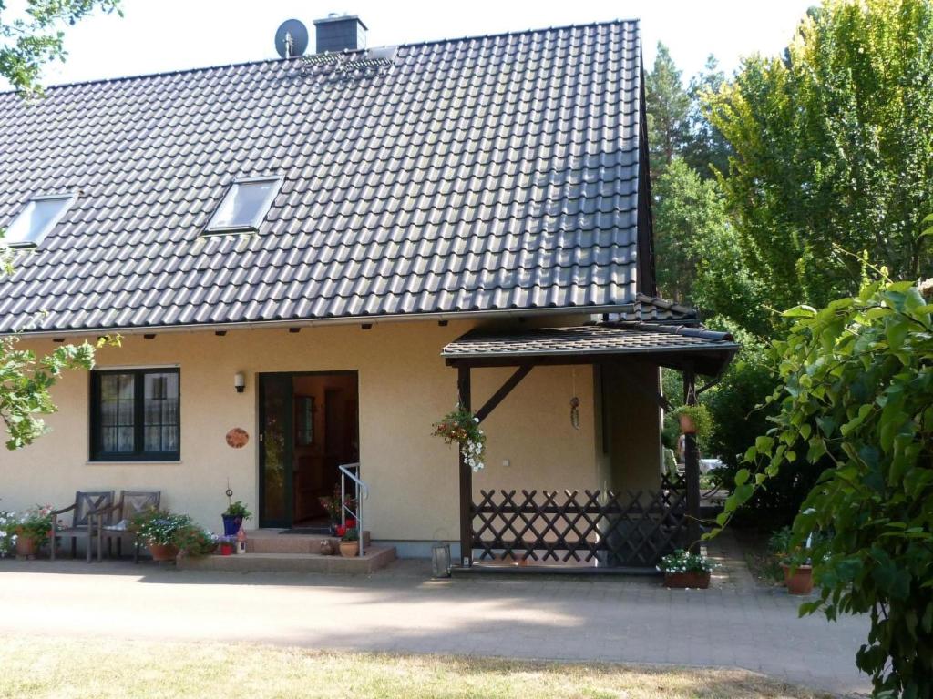 a small white house with a black roof at Apartment Am Marsfeld by Interhome in Borkheide