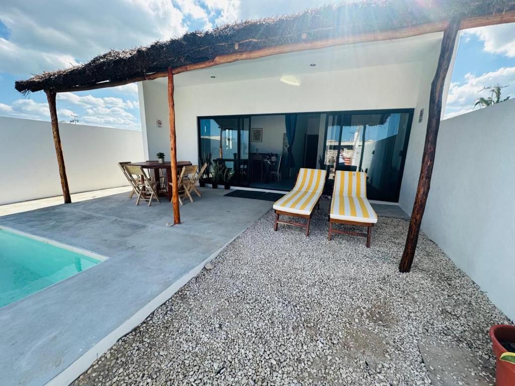 a patio with chairs and a table and a pool at La Conchita de Sisal 7 in Sisal