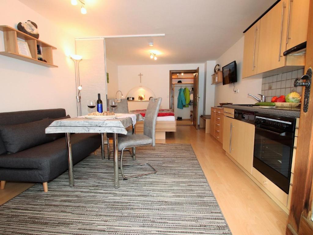 a kitchen and living room with a table and a couch at Apartment Igel by Interhome in Bad Bayersoien