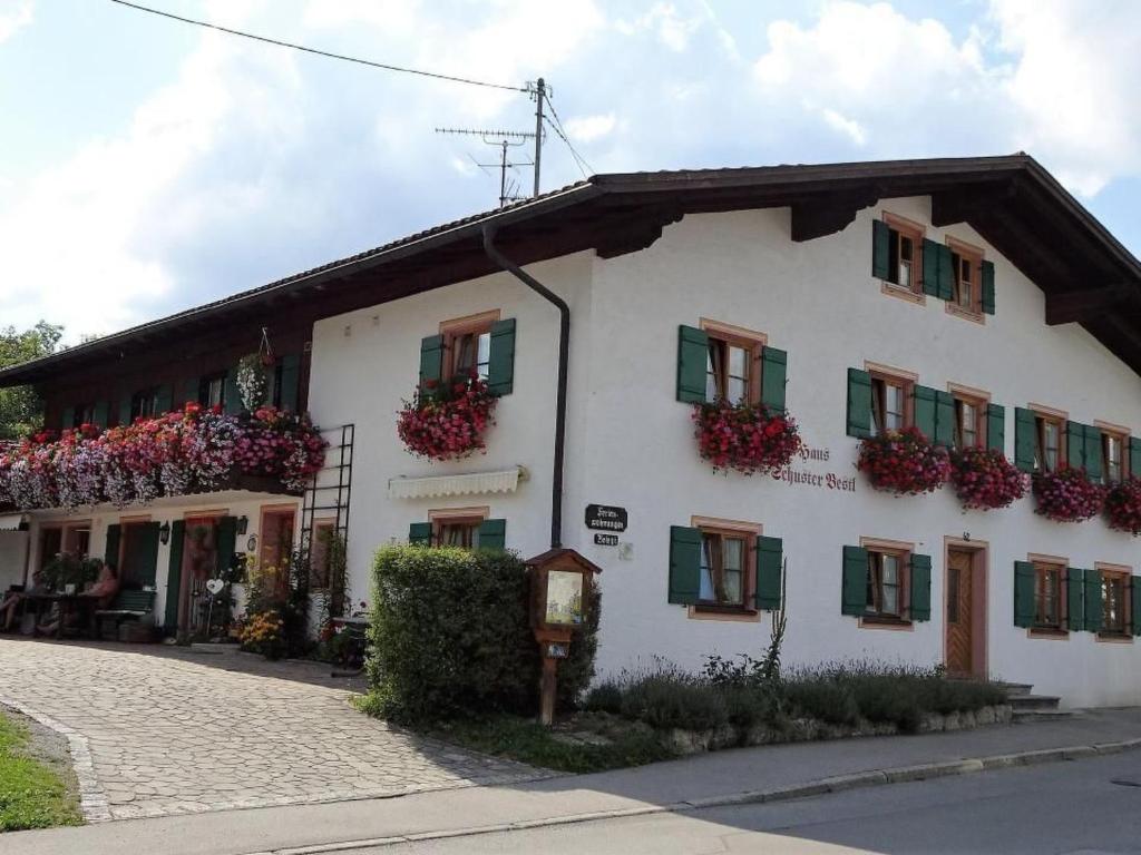 a white building with green shutters and flowers on it at Apartment FeWo Bärli by Interhome in Bad Bayersoien