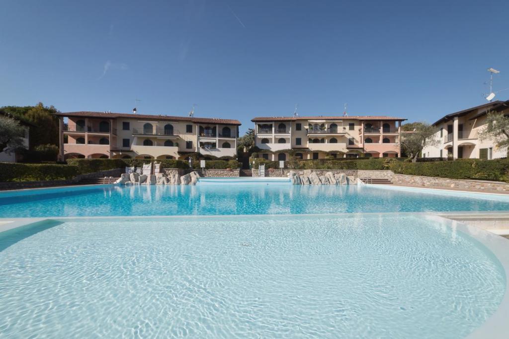 a large swimming pool with a fountain in front of buildings at Blu Garda View in Polpenazze del Garda