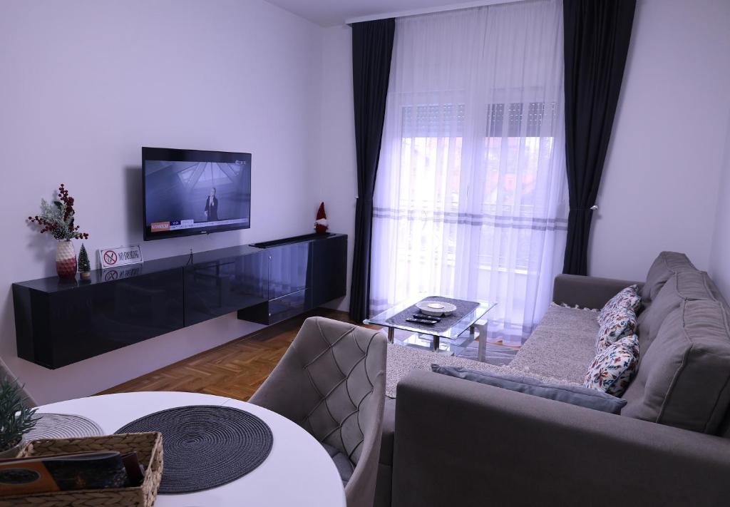 a living room with a couch and a flat screen tv at Splendid J&R apartman in Bijeljina