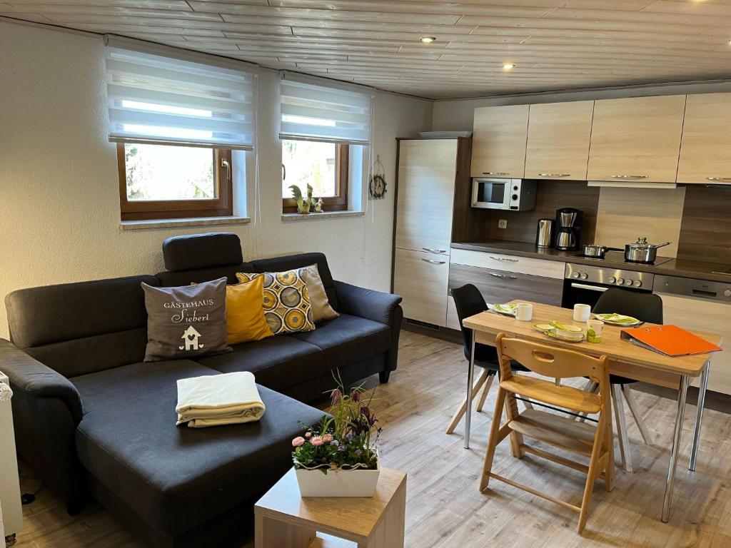 a living room with a couch and a table and a kitchen at Apartment FeWo Siebert by Interhome in Bad Brambach