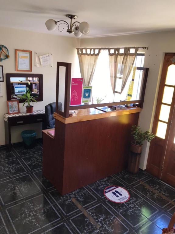 een kantoor met een receptiebalie en een bordje op de vloer bij Hostal Lucerna in Curanipe