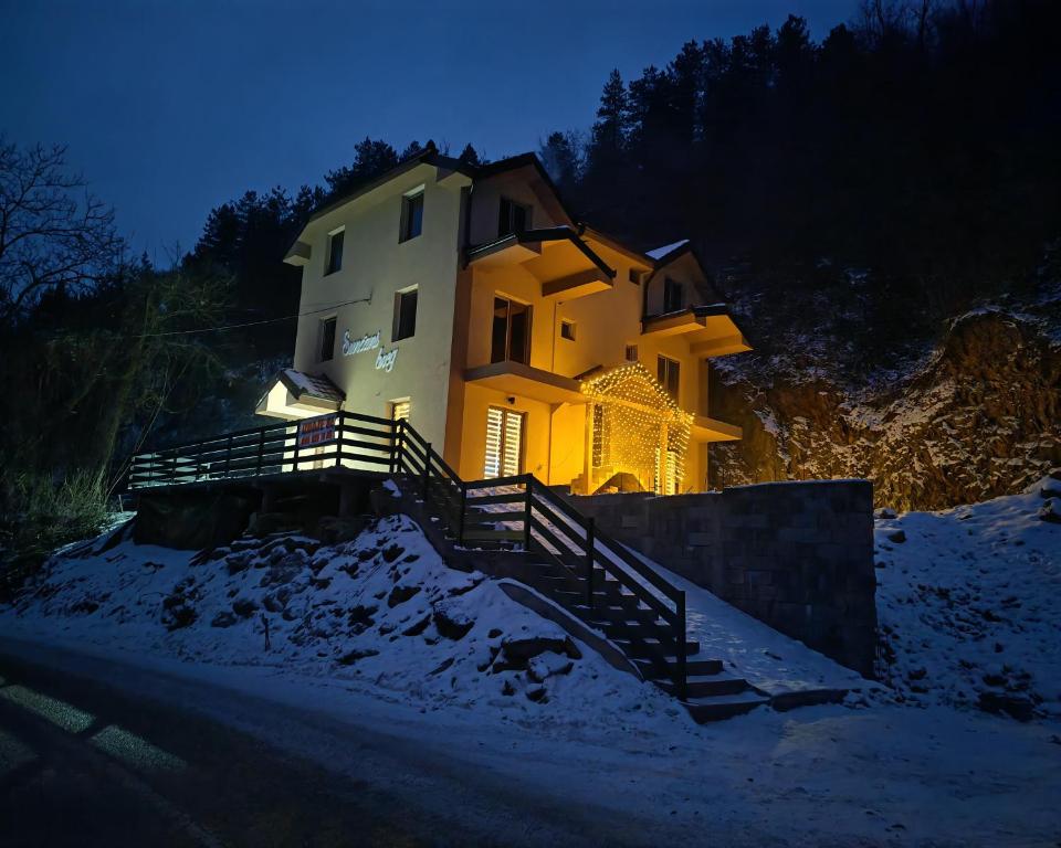 een huis dat bovenop een heuvel in de sneeuw staat bij Suncani breg in Crni Vrh