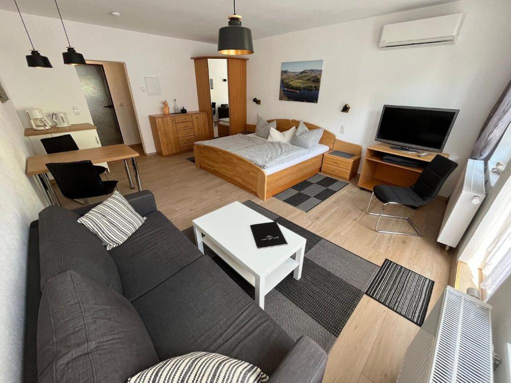 a living room with a couch and a bed at Apartment Haus Budinger by Interhome in Alf