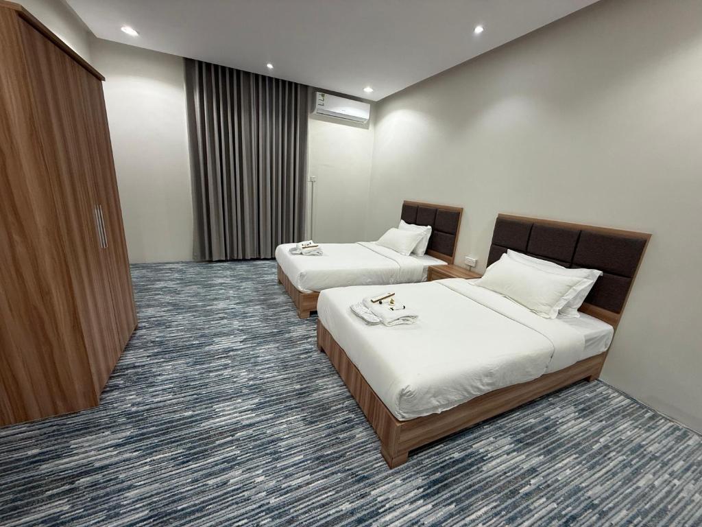 a hotel room with two beds and a closet at شقق دفادف المخدومة in Hail