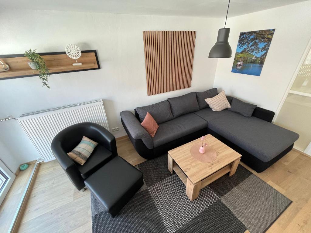 a living room with a black couch and a table at Apartment Haus Budinger by Interhome in Alf