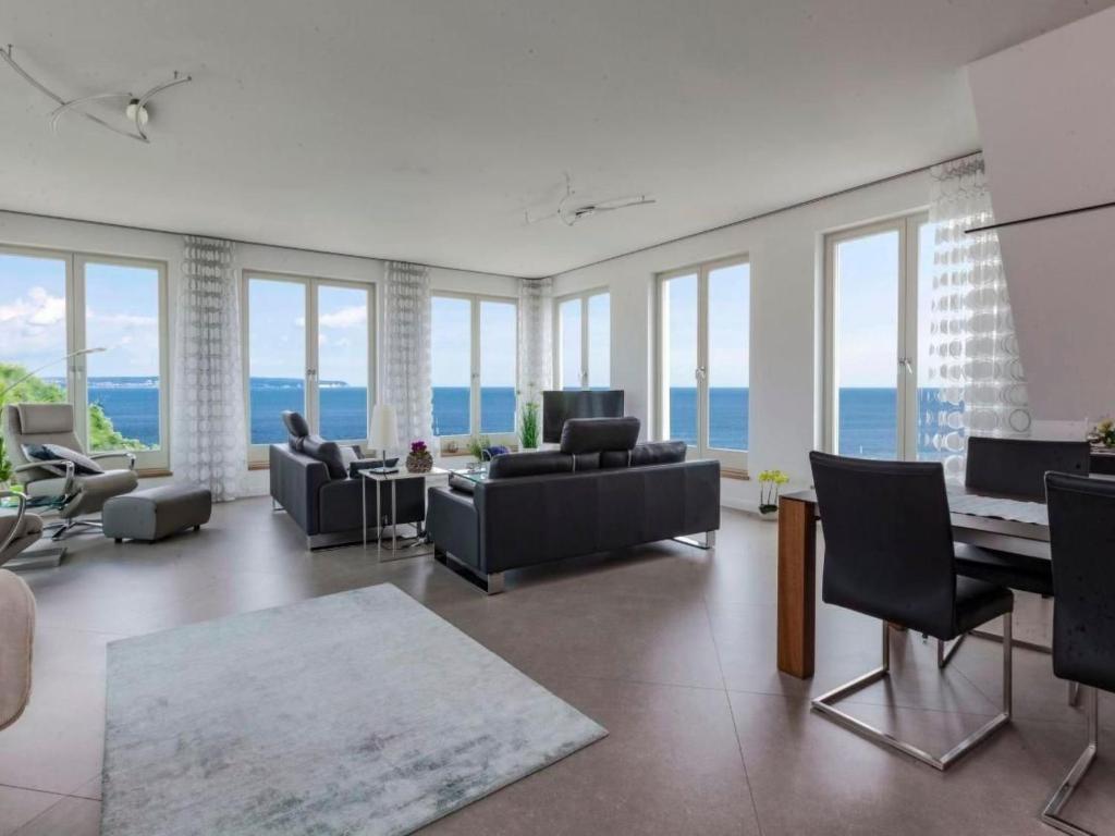 a living room with couches and a table and windows at Apartment Meerblick&SPA by Interhome in Ostseebad Sellin