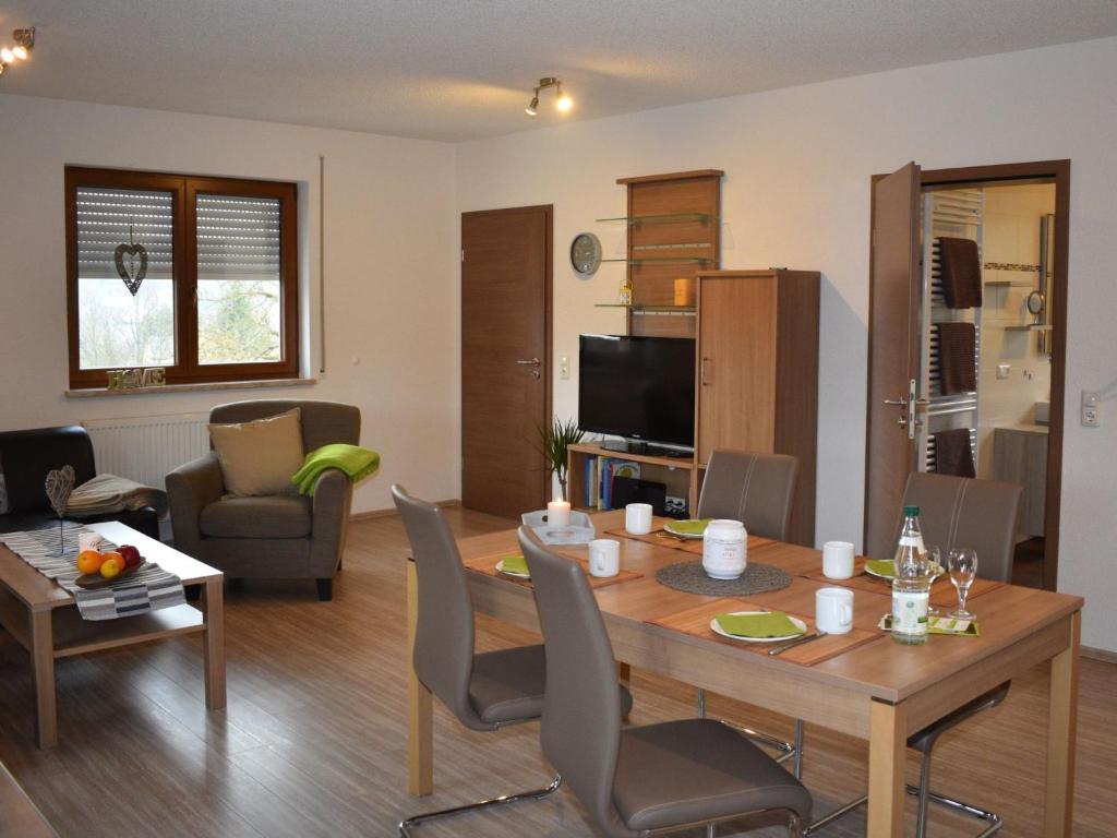 a living room with a wooden table and chairs at Apartment FeWo Siebert by Interhome in Bad Brambach