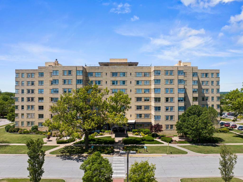 un grande edificio marrone chiaro con alberi di fronte di Hotel Phillips a Bartlesville