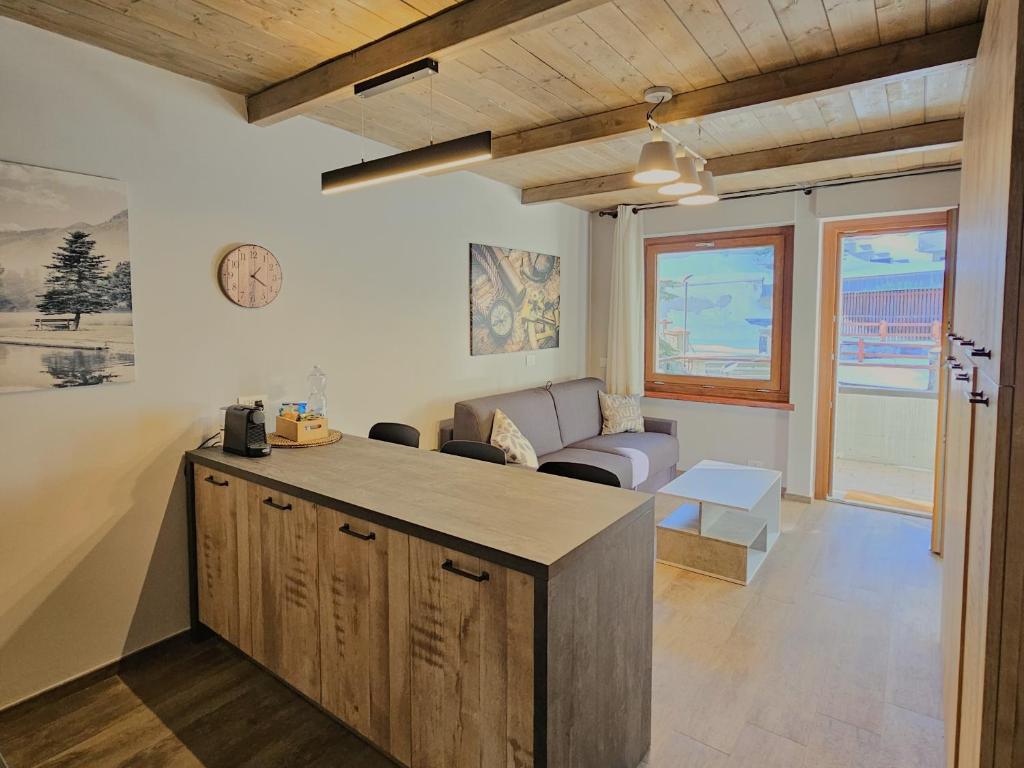 een keuken en woonkamer met een bank en een tafel bij Moda Apartments Scalette in Sestriere