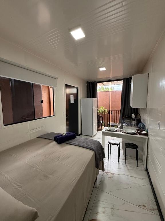 una camera da letto con un letto grande e una cucina di Loft 02 na Praia Brava a Itajaí