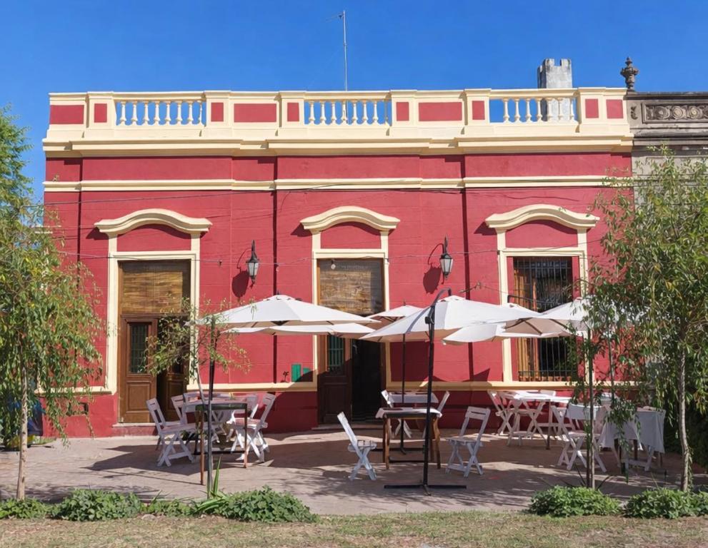 un edificio rosso con tavoli e ombrelloni di fronte di Ruka Fusión a Carlos Keen