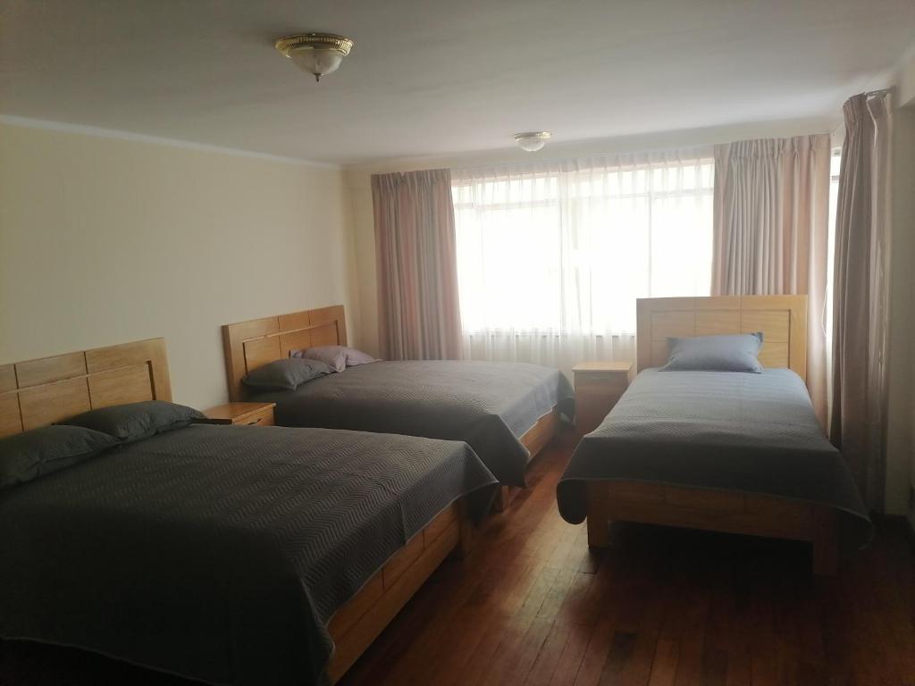 una camera da letto con due letti e una finestra di Casa ENLACE a La Paz