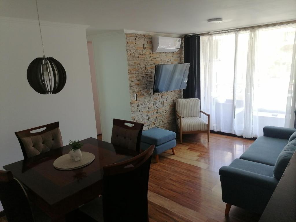 a living room with a table and a blue couch at departamento vacacional in Arica