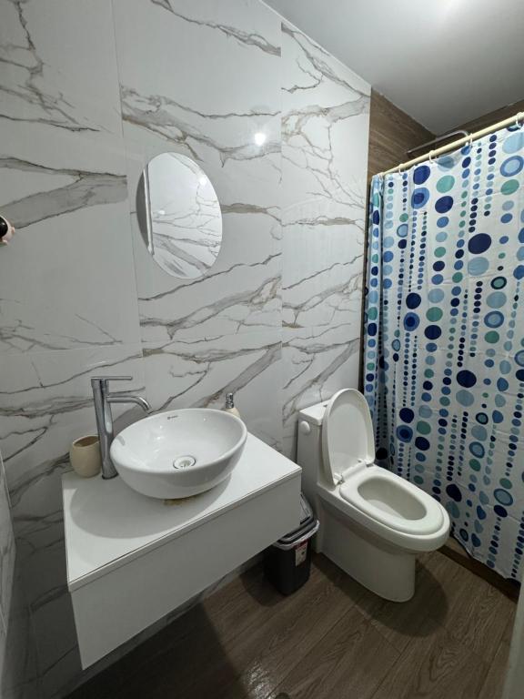a bathroom with a white sink and a toilet at Moderno Mn Depa en San Bartolo in San Bartolo