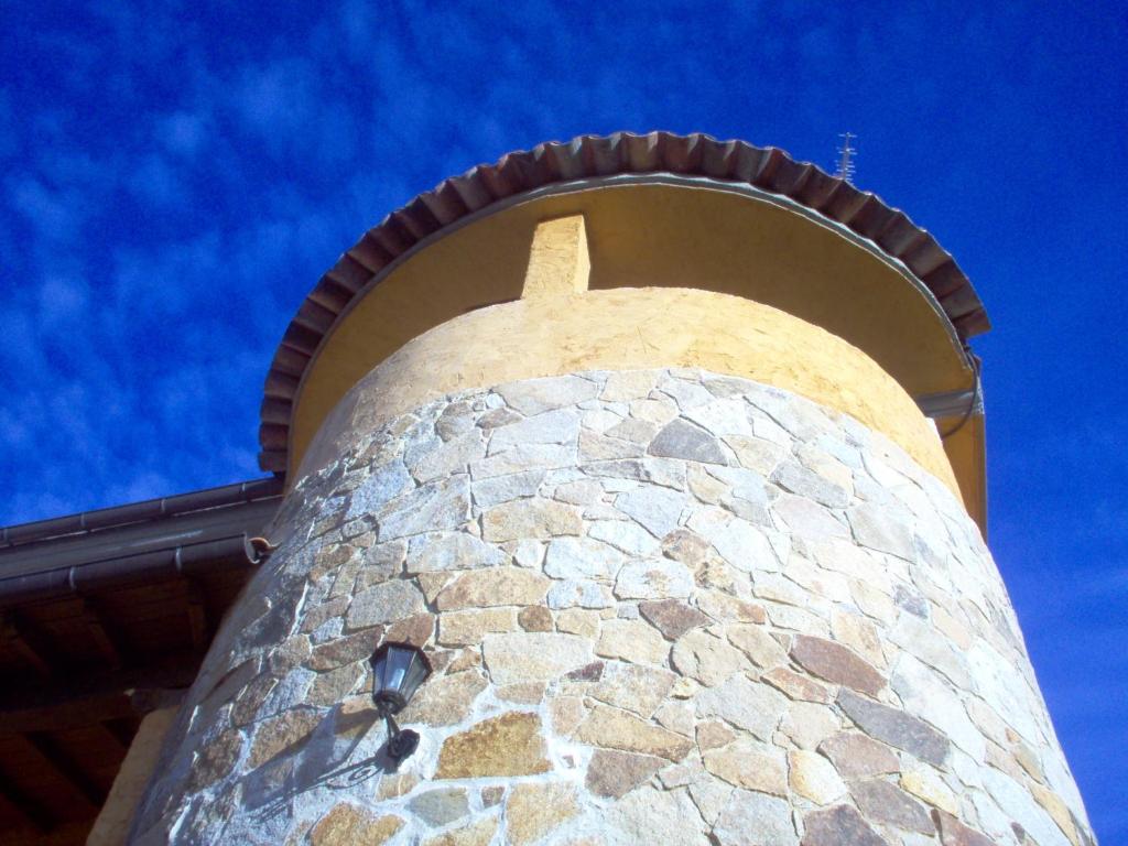 een hoge stenen toren met een hemel op de achtergrond bij Apartamento El Dragon Serrano in Sotoserrano