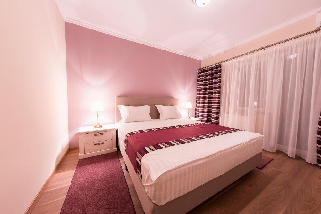 Un dormitorio con una cama grande y una ventana en Crema Residence, en Alba Iulia