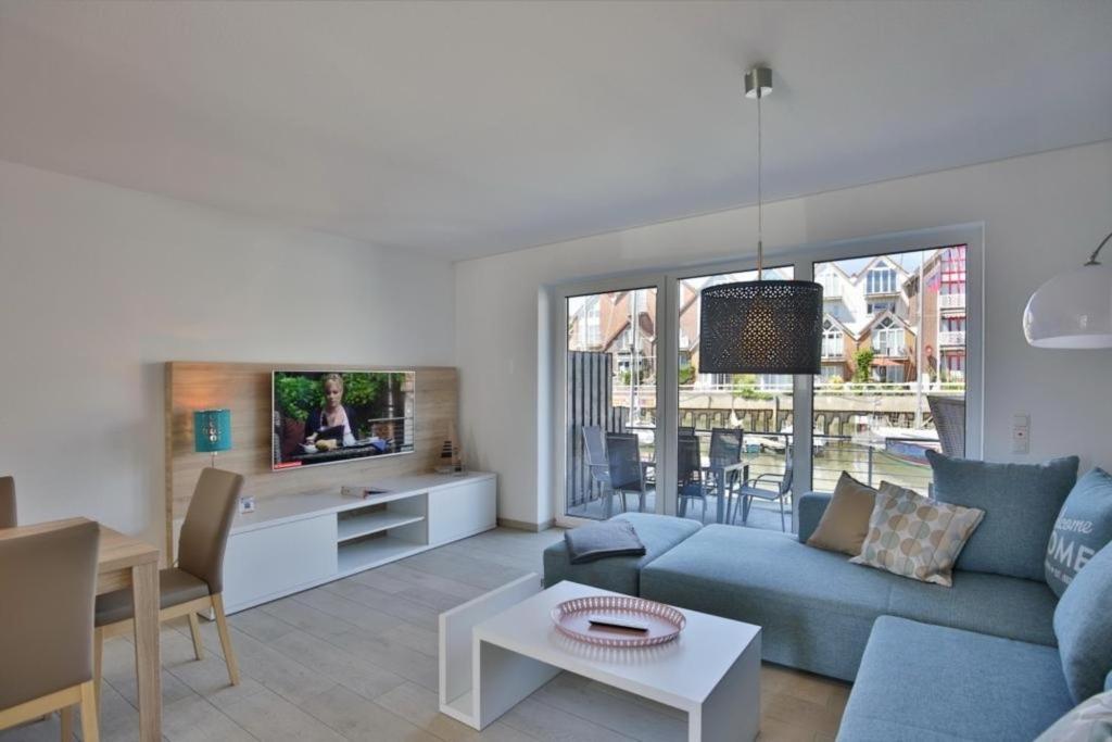 a living room with a blue couch and a table at City Marina, CM24b in Cuxhaven