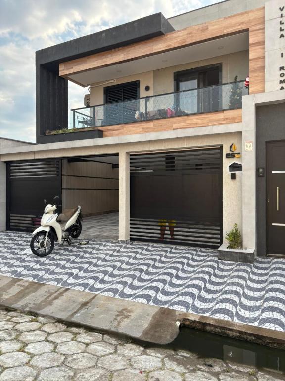 a motorcycle parked in front of a house at Casa de Praia Beta Simão in Praia Grande