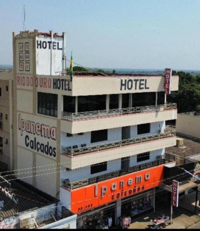 a hotel with an orange sign on top of it at Hotel Rio do Ouro in Porangatu