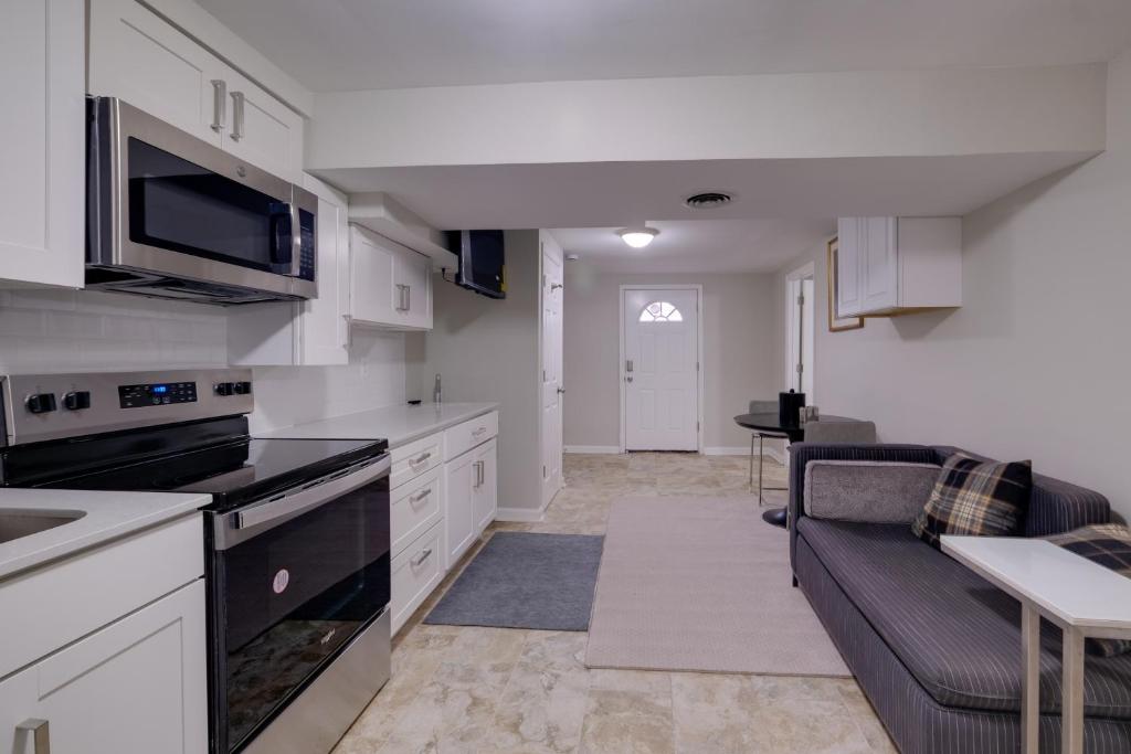 a kitchen with a couch and a living room at Work & Explore, Cozy Unit 5 Mi to UMD! in Lanham