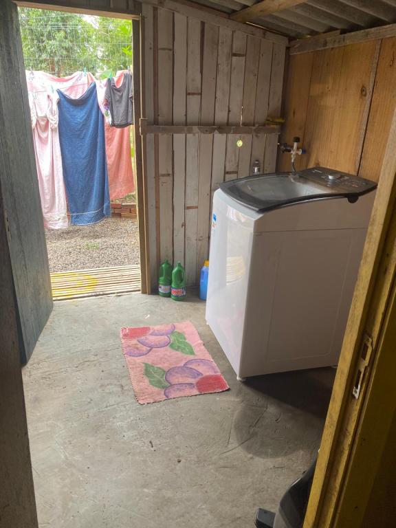 een keuken met een wasmachine en een tapijt bij Casa de campo in Passo De Torres