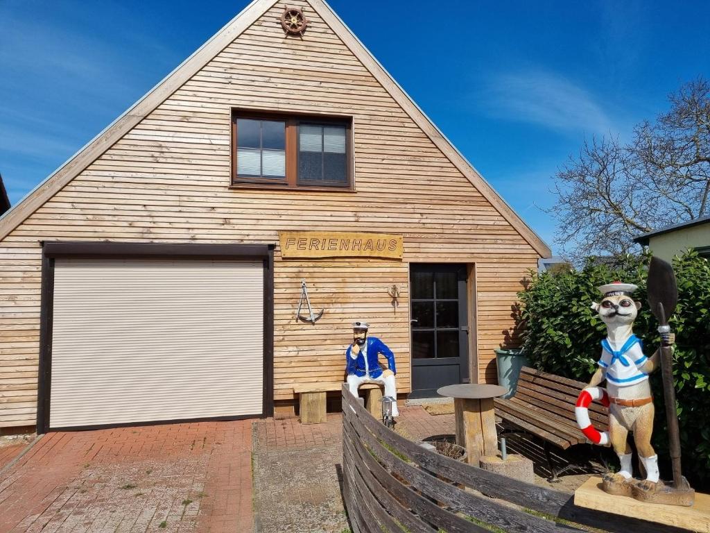 un edificio di legno con un uomo seduto di fronte di Ferienhaus "Trojan" a Zierow