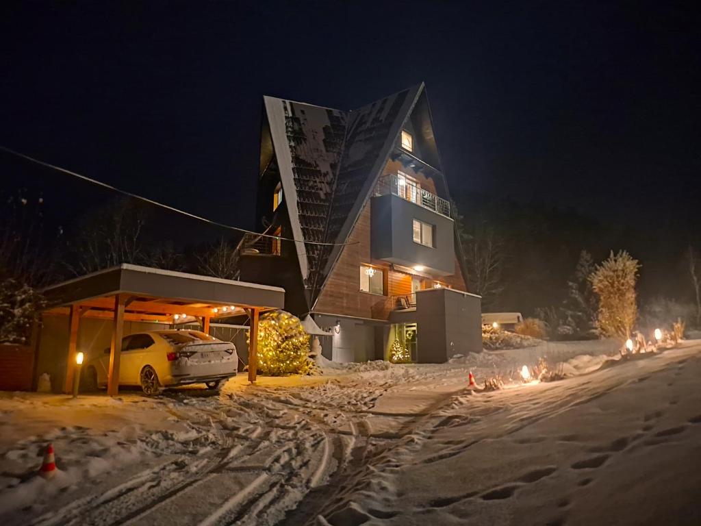 een gebouw met een auto in de sneeuw 's nachts bij Vila Anna Wellness in Halenkov