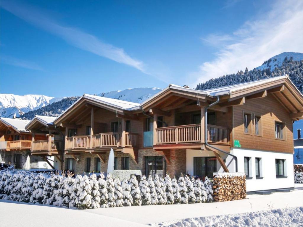 een huis in de sneeuw met bergen op de achtergrond bij Salzach Lodge in Piesendorf