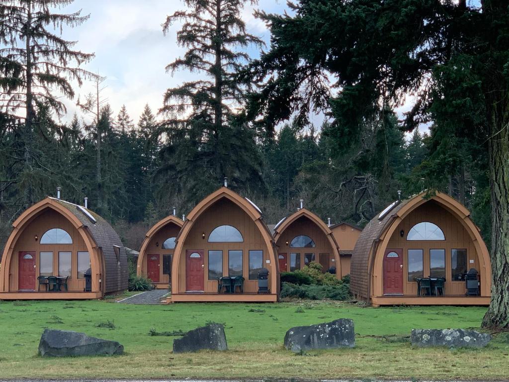 a row of domed buildings in a field with trees at Oyster Bay Resort in Oyster Bay