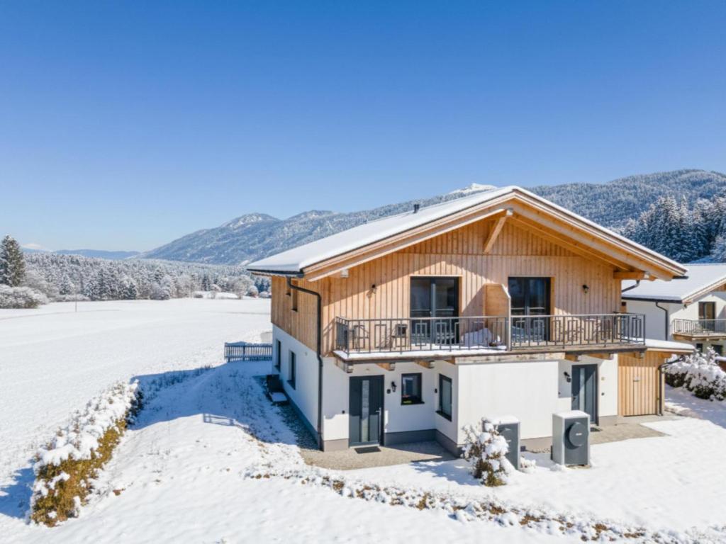 een huis met een balkon in de sneeuw bij Sauna Chalet 9B in Hermagor