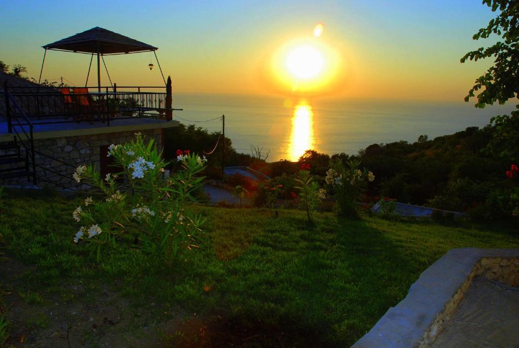 a sunset over the ocean from a house at Panorama Villas in Drymon