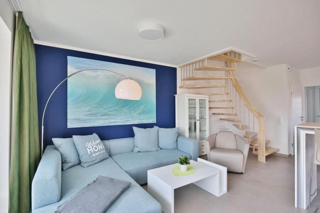 a living room with a blue couch and stairs at City Marina, CM16c in Cuxhaven