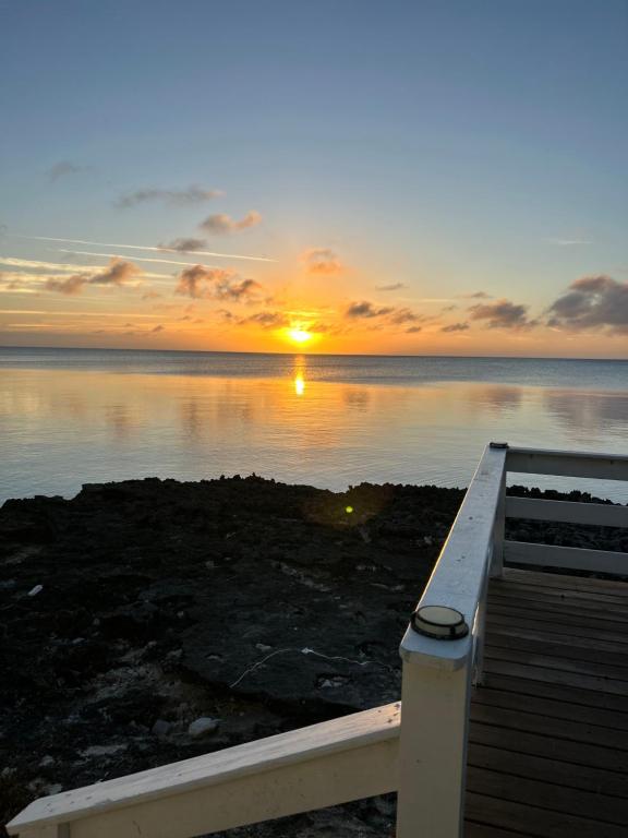 a sunset over the water with a wooden pier at Sunsetville in Savannah Sound