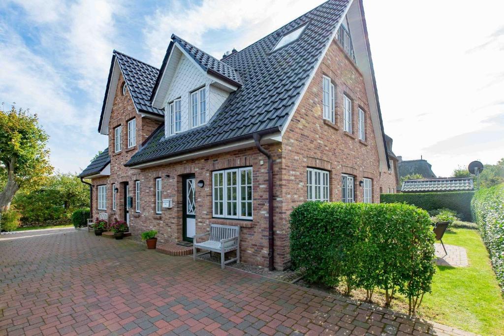 un grande edificio in mattoni con una panca di fronte di Haus Landleben a Goting
