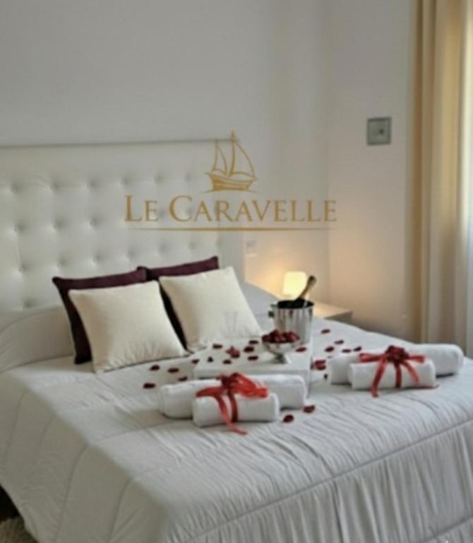 a large white bed with red roses on it at Le Caravelle in Mestre