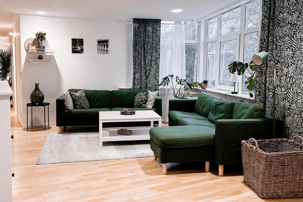 a living room with a green couch and a table at LichtLoft Pirna Altstadt mit 4 Schlafzimmer und XXL Wohnküche in Pirna