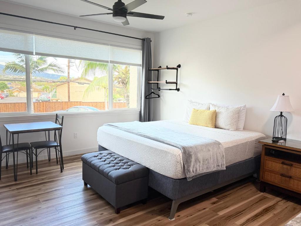 een slaapkamer met een bed, een tafel en een raam bij Unit 5 Waena Inn Newly Renovated Maui Private Suite in Wailuku
