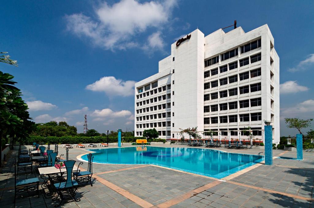 a building with a swimming pool in front of a building at Clarks Avadh in Lucknow