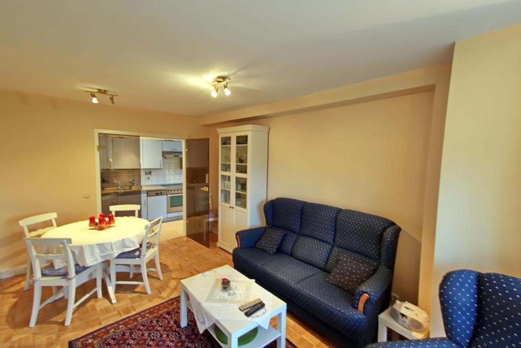 a living room with a blue couch and a table at Ruhetal in Tinnum