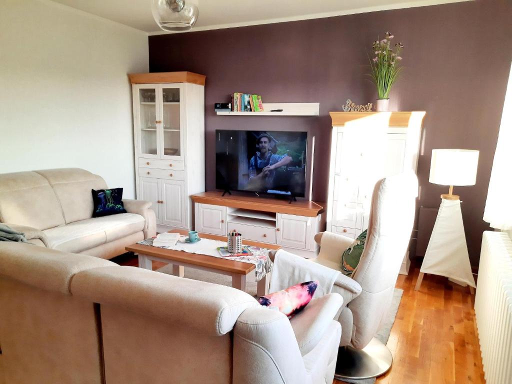 a living room with two couches and a tv at Romantischer Rückzugsort in Kröpelin in Strandnähe in Kröpelin