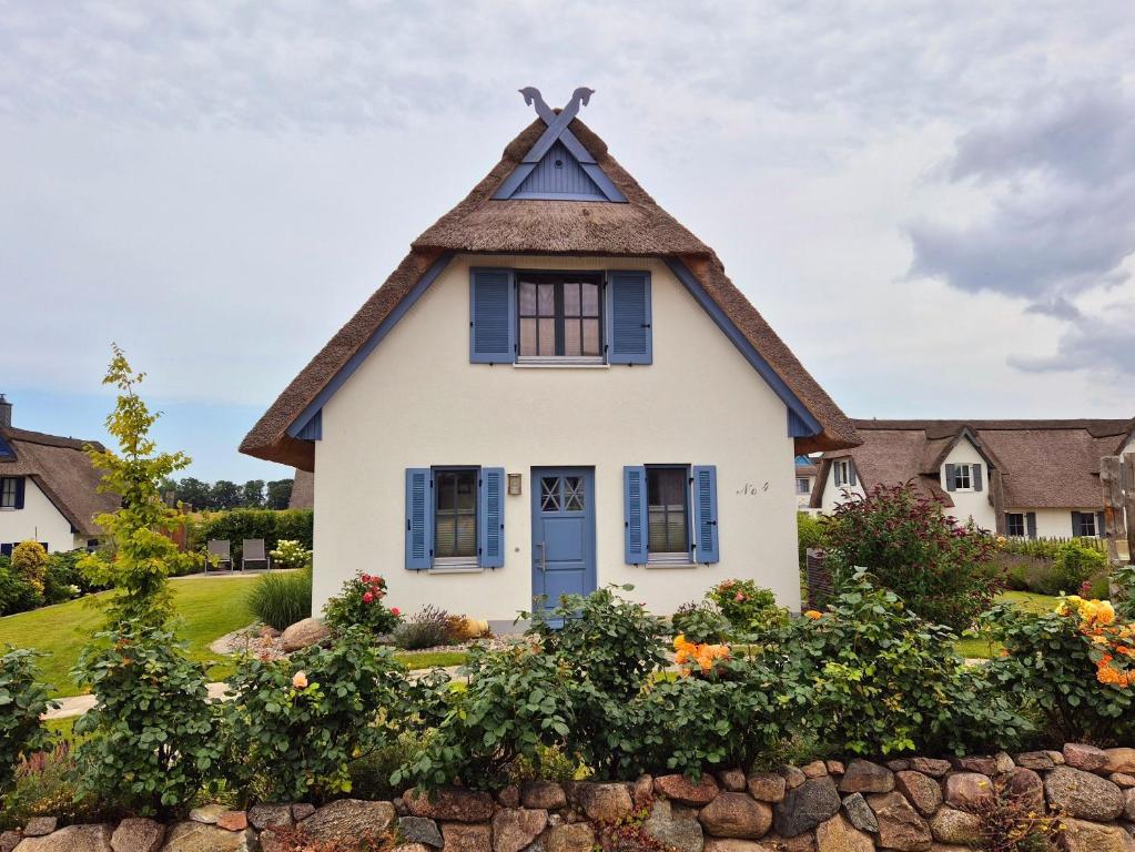 a white house with a thatched roof at Reethaus "Dat Lavendelhus" in Zierow