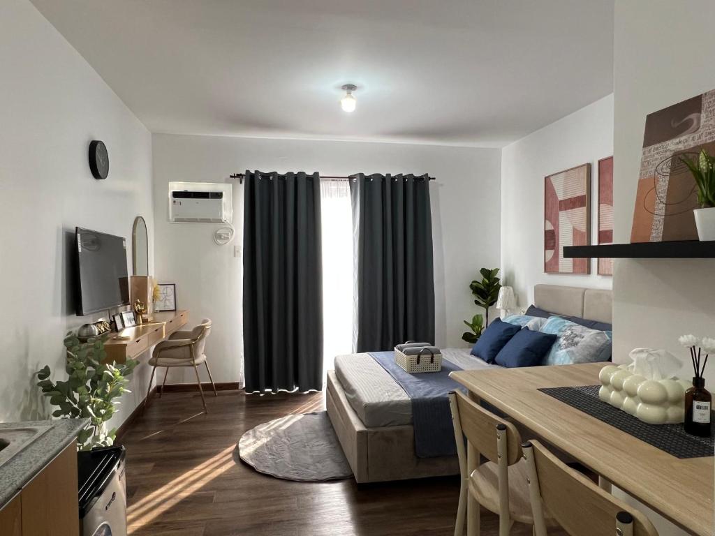 a bedroom with a bed and a kitchen with a table at JeMeCa Suites in Kauswagan