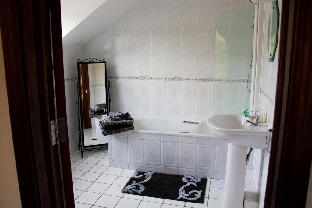 een badkamer met een wit bad en een wastafel bij Murray's Mountain View in Castlemaine
