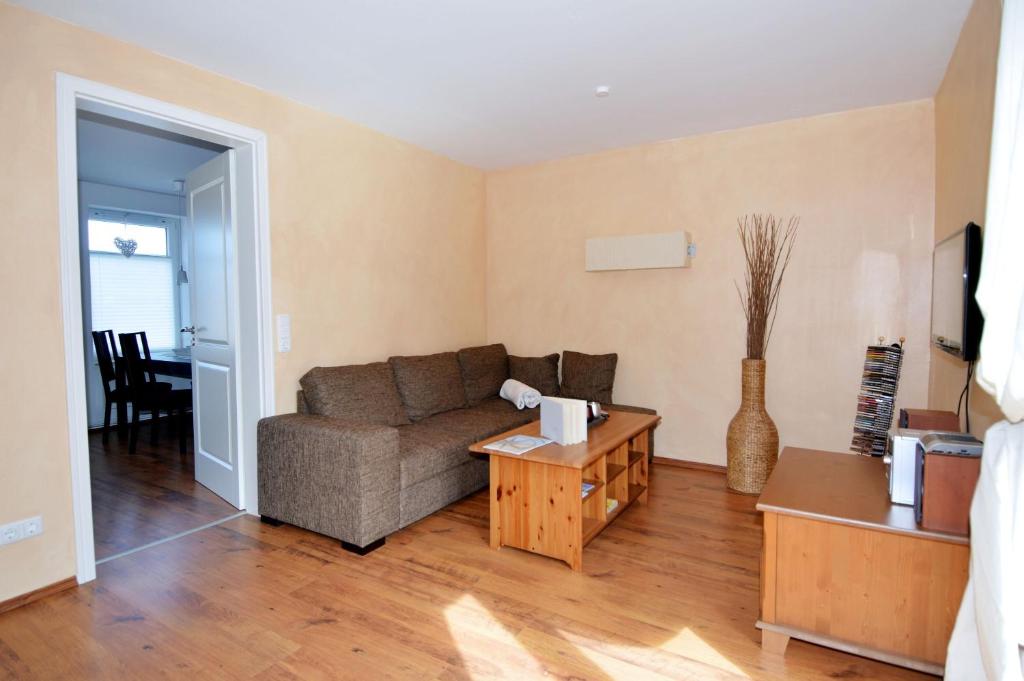ein Wohnzimmer mit Sofa und Tisch in der Unterkunft Wendstraße 10, Ferienhaushälfte in Heiligenhafen